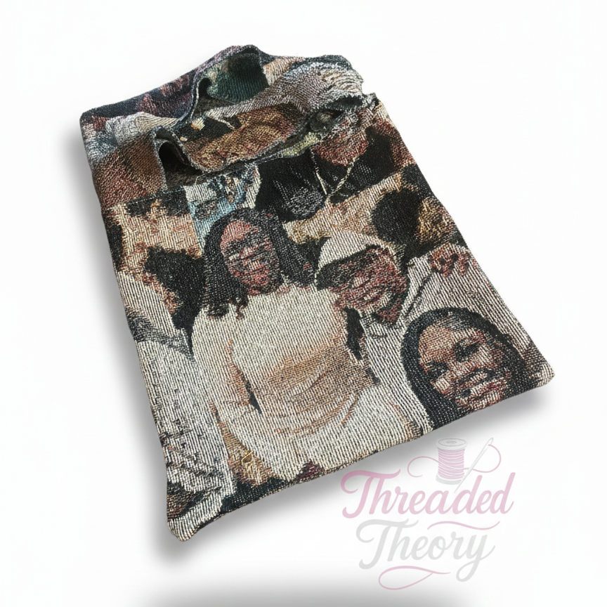 Folded fabric with printed faces on a white background, featuring the brand 'Threaded Theory'.